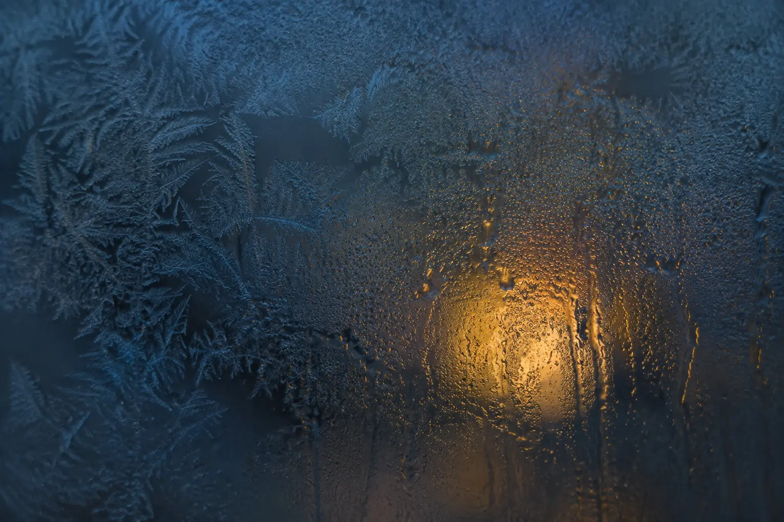 Frost and condensation across dark glass